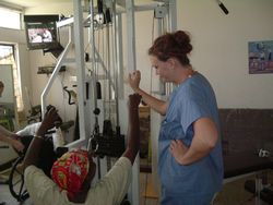 physiotherapy medical volunteer assists in a spinal injury clinic