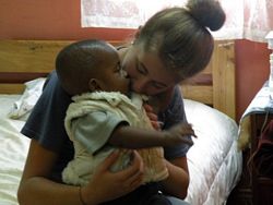 Emily from USA cuddling a baby -  Volunteer in East Africa